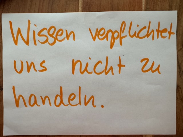 Handgeschriebener Satz: Wissen verpflichtet uns nicht zu handeln.